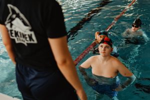 Instruktor nauki pływania z dziećmi w wodzie na basenie w Herbach